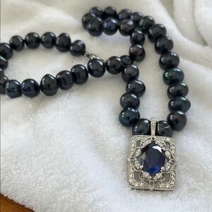 Luxurious navy pearls and detachable Silver with blue stone enhancer pendant.